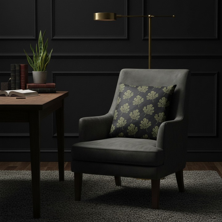 Dark gray armchair with a patterned pillow in a dimly lit room.